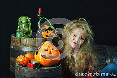 Cute little girl in the form of a witch with pumpkins Stock Photo