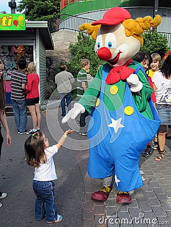 Cute little girl greeting a clown Editorial Stock Photo