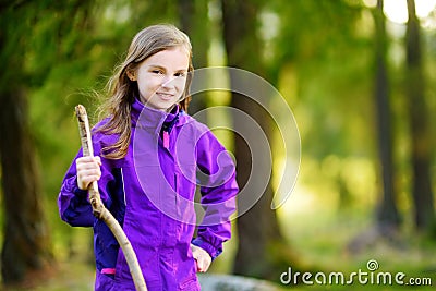 Cute little girl having fun during forest hike on beautiful autumn day in Italian Alps Stock Photo