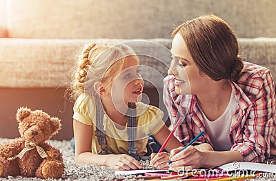 Cute Little Girl and Her Beautiful Mother Drawing. Stock Photo