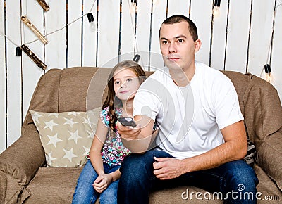 Cute little girl and her father watching tv Stock Photo