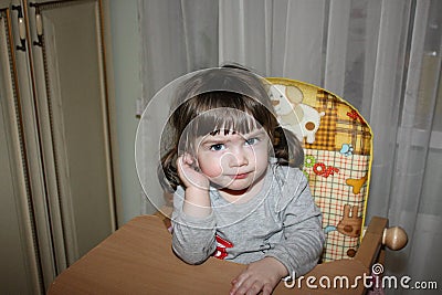 Cute little girl in a high chair Stock Photo