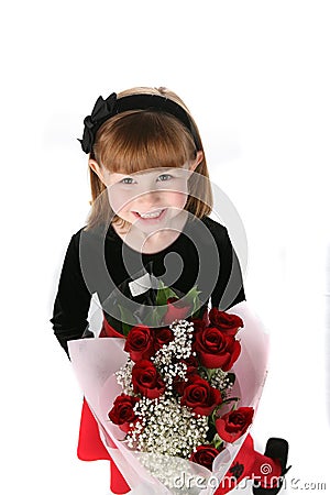 Cute little girl in holiday dress with red roses Stock Photo