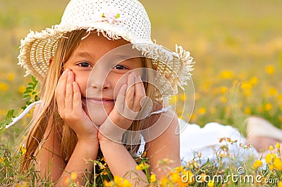 Cute little girl lying on the meadow on sunny day Stock Photo