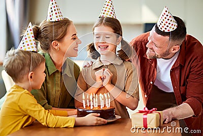 Cute little girl making wish while celebrating Birthday with family at home Stock Photo