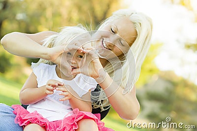 Cute Little Girl With Mother Making Heart Shape with Hands Stock Photo