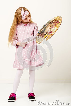 Little girl with palette and brush learning to draw. Stock Photo