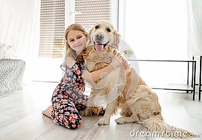 Cute little girl playing with beautiful goden retriever dog Stock Photo
