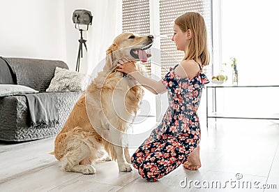 Cute little girl playing with beautiful goden retriever dog Stock Photo