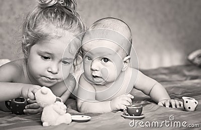 Cute little girl is playing with his younger brother Stock Photo