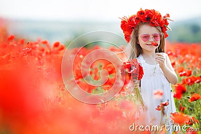 Cute little girl playing in red poppies field summer day beauty and happiness France Stock Photo