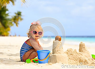 Cute little girl playing with sand on beach Stock Photo