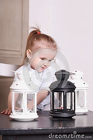 Cute little girl playing with three luminaires with candle Stock Photo