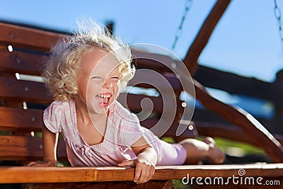 Cute little girl playing on wooden chain s Stock Photo