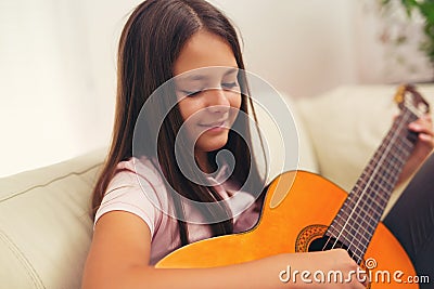 Cute little girl practicing her guitar lessons Stock Photo