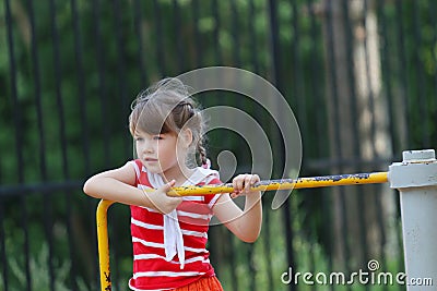Cute little girl in red whirls on roundabout Stock Photo