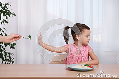 Cute little girl refusing to eat her breakfast at home Stock Photo