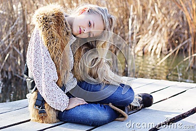 Cute little girl is resting near lake Stock Photo