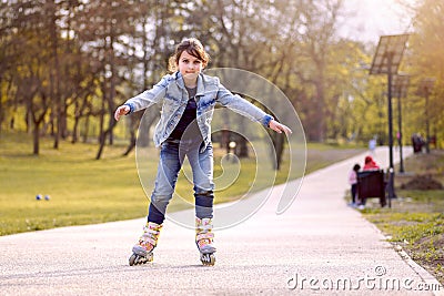 Young girl rides inline skating rollerblades in the park Stock Photo