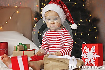 Children under Christmas tree with gift boxes. Stock Photo