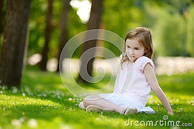 Cute little girl sitting on a clover field Stock Photo