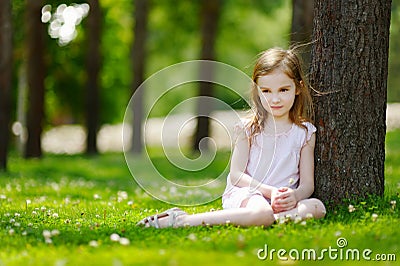 Cute little girl sitting on a clover field Stock Photo