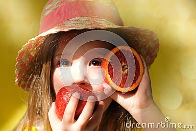Cute little girl in straw hat licking orange fruit. gift tour for all family. Happy weekend. Health diet Stock Photo