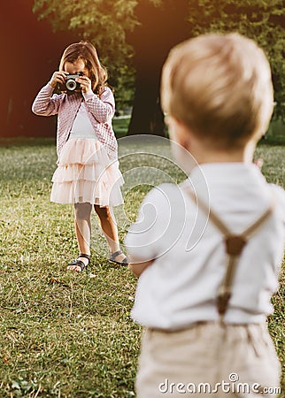 Cute little girl taking a phto of her younger brother Stock Photo