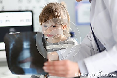 Cute little girl talking with gp looking at xray picture during consultation Stock Photo