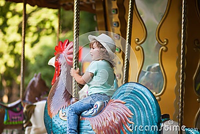 Toddler kid riding vintage roundabout carousel. Stock Photo