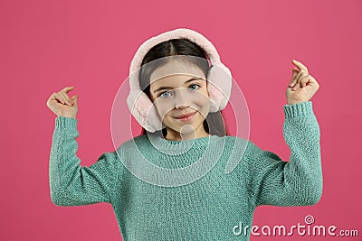 Cute little girl wearing stylish earmuffs on pink Stock Photo