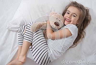 Cute little girl in bed with soft toy Stock Photo