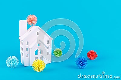 Cute little house and plastic balls as viruses on blue. Epidemic, social isolation, coronavirus COVID-19 concept Stock Photo