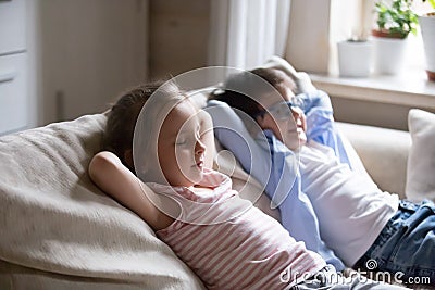 Cute boy and girl lying on cozy sofa relaxing Stock Photo