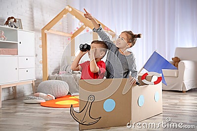 Cute little kids playing with binoculars and cardboard boat Stock Photo