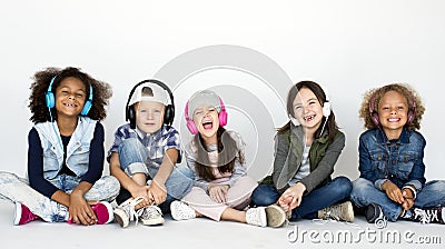 Cute Little Kids Sitting Listening to Music Stock Photo