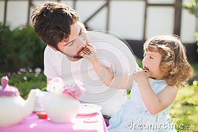 Cute little lady playing tea party with her caring father Stock Photo