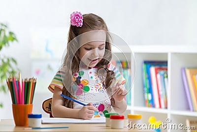 Cute little preschooler child girl drawing color pencils at home or studio Stock Photo