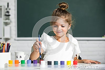 Cute little preschooler child girl drawing at school. Child girl painting on elementary school. Little funny artist Stock Photo