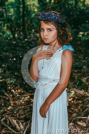 Cute little princess girl with blue butterflies in the forest. Art processing Stock Photo