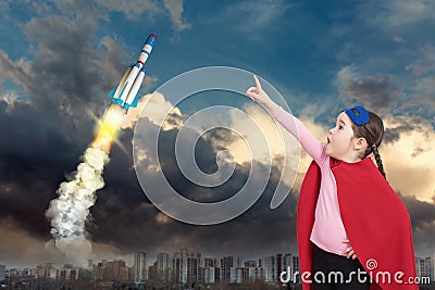 Cute little super hero girl in the red cloak and a speceship Stock Photo