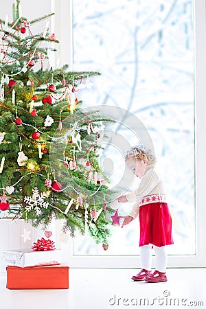 Cute little toddler girl decorating Christmas tree Stock Photo