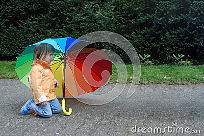 Toddler girl with umbrella in rainbow colors Stock Photo