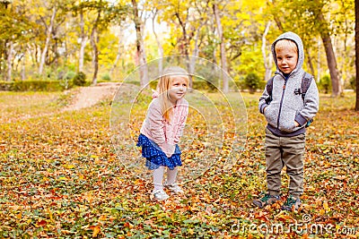 Cute little twins boy and girl playing together in autumn park Stock Photo