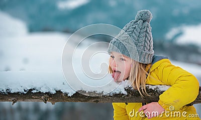 Cute little winter girl eating snow outdoor. Excited christmas kids holiday. Kids cold and flu concept. Kid lick snow Stock Photo