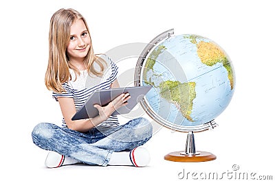 cute little young girl with tablet and globe. Schoolgirl using modern technology in teaching geography Stock Photo