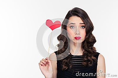 Cute lovely sad curly girl holding heart booth Stock Photo