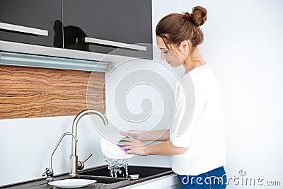 Cute lovely woman standing and washing dishes Stock Photo