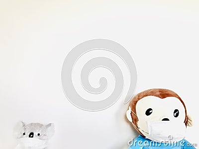 Cute monkey and Koala soft toy wearing a face mask with pale white background. Stock Photo