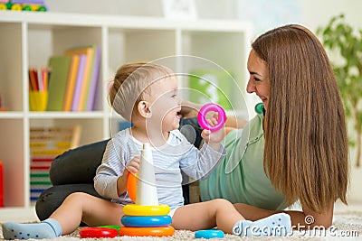 Cute mother and baby boy play together indoor at Stock Photo